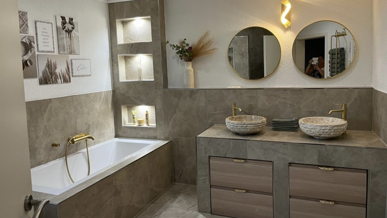 Elegantes Bad mit Doppelwaschtisch und goldenen Armaturen